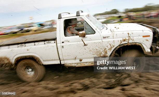 Driver ploughs through the mud as revellers celebrate Australia's affinity of the iconic ute, or pickup, at the annual Deniliquin Ute Muster, which...