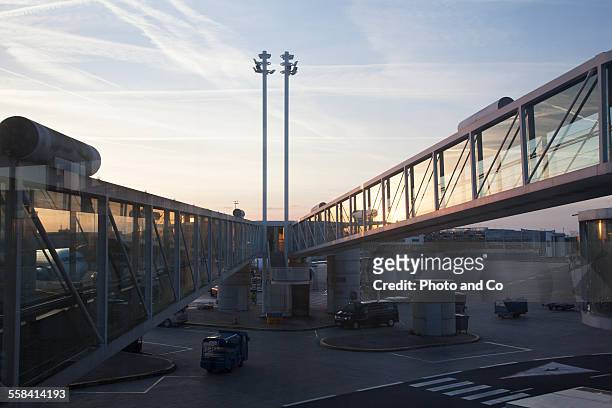 passenger boarding bridge on airport tarmac - passenger boarding bridge stock-fotos und bilder