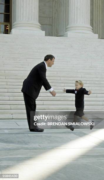 Washington, UNITED STATES: US Supreme Chief Justice John G. Roberts, Jr. Is greeted by his son Jack outside the Supreme Court 03 October, 2005 in...