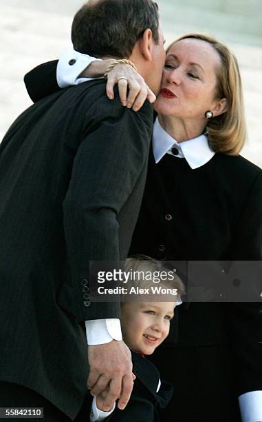 Supreme Court Chief Justice John G. Robers kisses his wife, Jane, as his son, Jack, stands with them after an investiture ceremony at the Supreme...