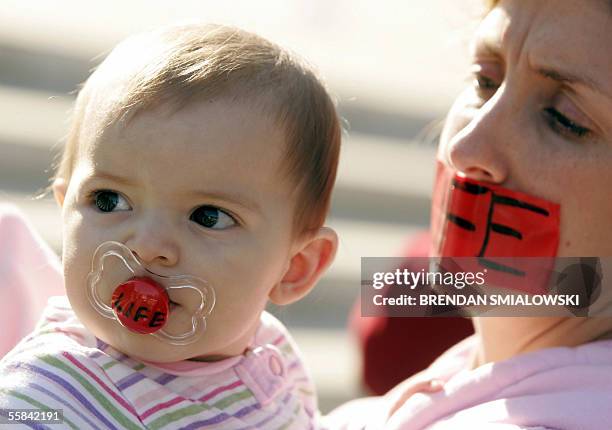Washington, UNITED STATES: A pro-life activist holds a baby during a prayer rally outside of the US Supreme Court 03 October, 2005 in Washington, DC...