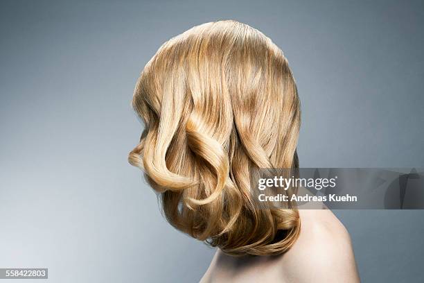 young woman with blond hair covering her face. - shiny wavy hair stock pictures, royalty-free photos & images