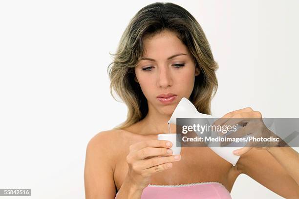 portrait of woman pouring water into cup, close-up - copo de saké - fotografias e filmes do acervo