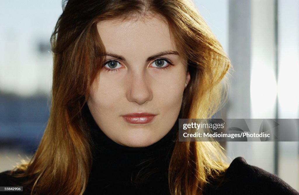 Portrait of serious woman with reddish brown long hair, close-up