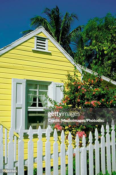 close-up of a yellow house with white shutters and white picket fence, dunmore town, harbor island, bahamas - dunmore town stock pictures, royalty-free photos & images