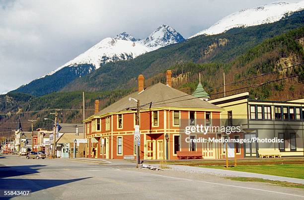 buildings in front of snowcapped mountain, klondike gold rush national historic park, skagway, alaska, usa - skagway stock-fotos und bilder