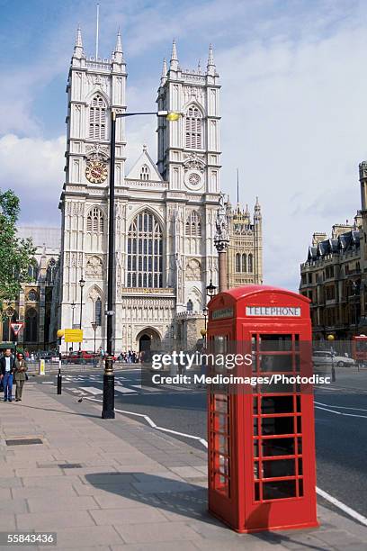 telephone booth in front of westminster abbey, london, england - abby road stock-fotos und bilder