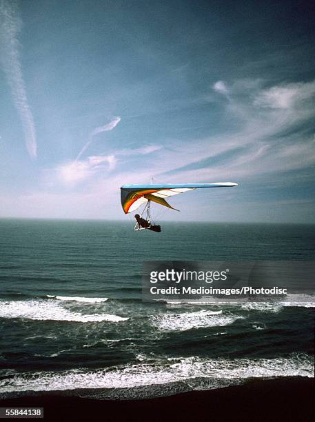 hang glider over the ocean - drachenfliegen stock-fotos und bilder