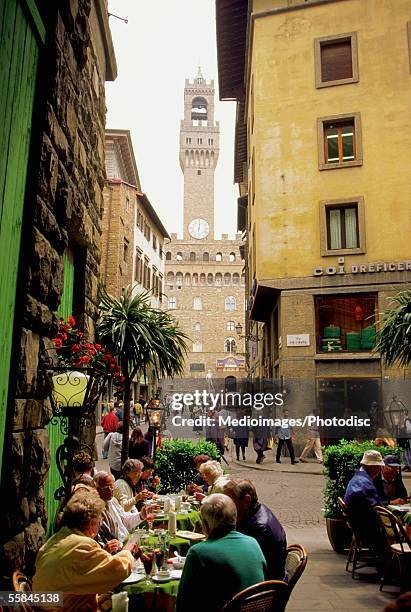 tourists eating at sidewalk cafe, palazzo vecchio, florence, italy - campanário florença imagens e fotografias de stock