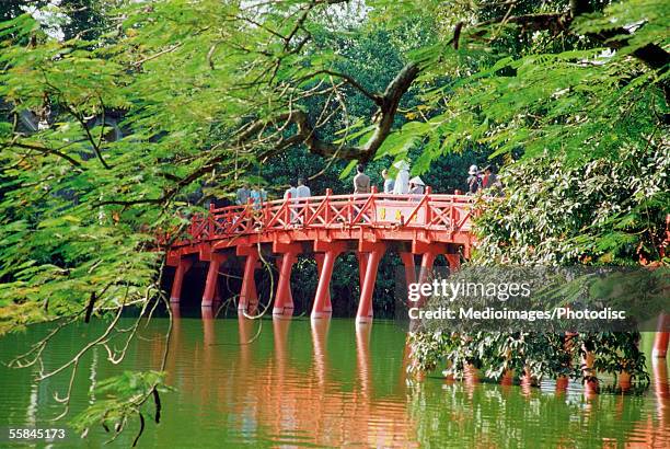 people walking on a bridge, huc bridge, haan kiem lake, hanoi, vietnam - huc bridge stock pictures, royalty-free photos & images