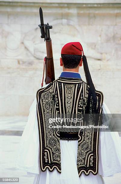 rear view of a guard in traditional clothing standing outside parliament building, athens, greece - garder photos et images de collection
