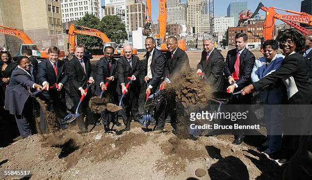 Dignitaries, team and city officials shovel dirt during the groundbreaking ceremony at the site of the New Jersey Devils' new home, the Newark Arena,...