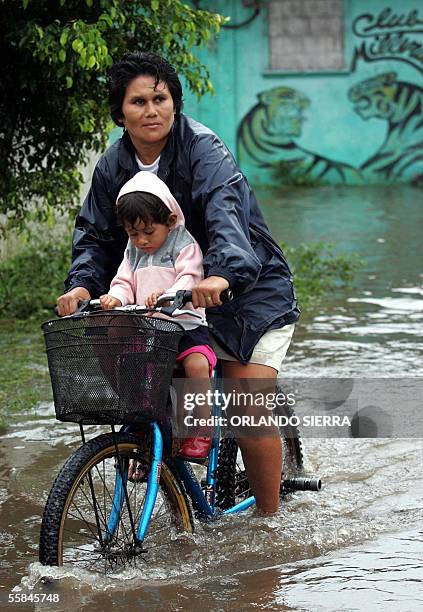 Una mujer y su hijo circulan en bicicleta en una de las calles inundadas de Puerto de San Jose, 100 kms al sur de Ciudad de Guatemala, el 03 de...
