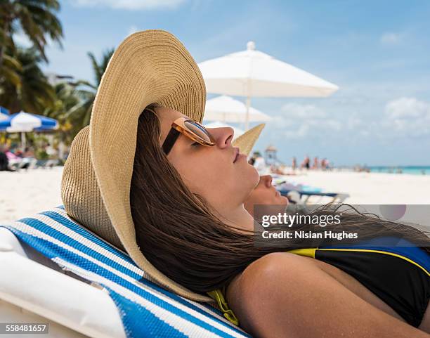 portaite of woman in beach chair on beach - mujeres latinas stock-fotos und bilder