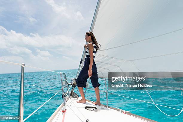 woman standing at the bow of sailboat - hot women on boats stock pictures, royalty-free photos & images