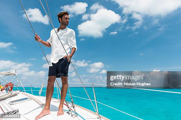 man standing on deck of sailboat - boat top view stock-fotos und bilder