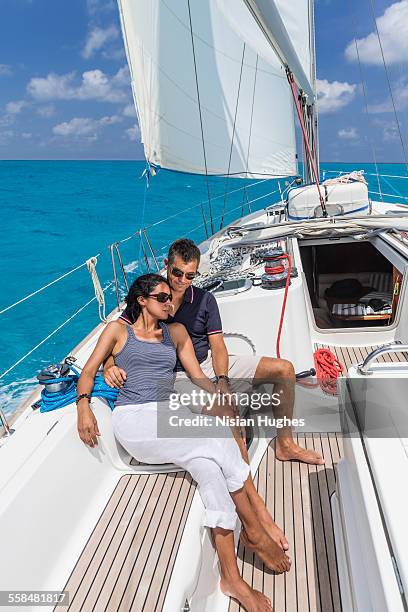 mature couple sitting together on sailboat - mujeres latinas stock-fotos und bilder