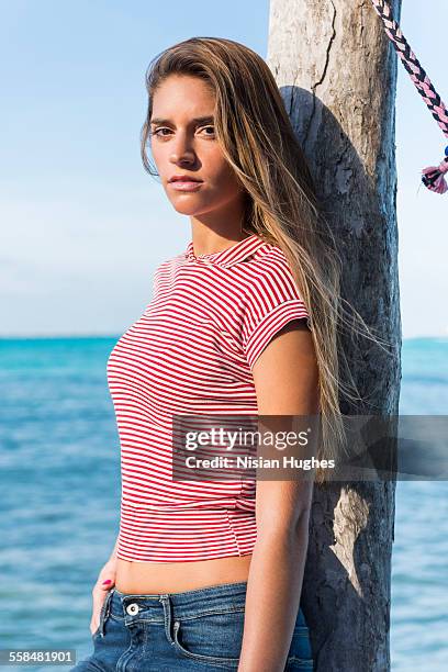 woman standing at end of pier looking at camera - mujeres latinas stock-fotos und bilder