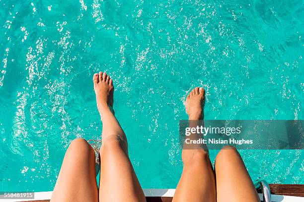 womans legs and feet in clear blue water - sun tan legs stock pictures, royalty-free photos & images