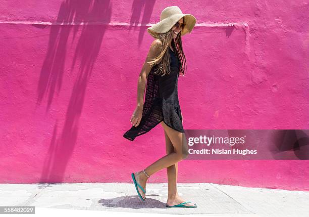 woman with sun hat walking against bright wall - pink sandals for women stock pictures, royalty-free photos & images