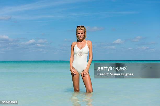 young woman standing in beautiful ocean - mujeres hot stock-fotos und bilder