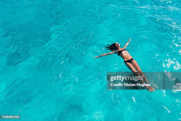 woman floating on her back, swimming in ocean - floating on water stock pictures, royalty-free photos & images