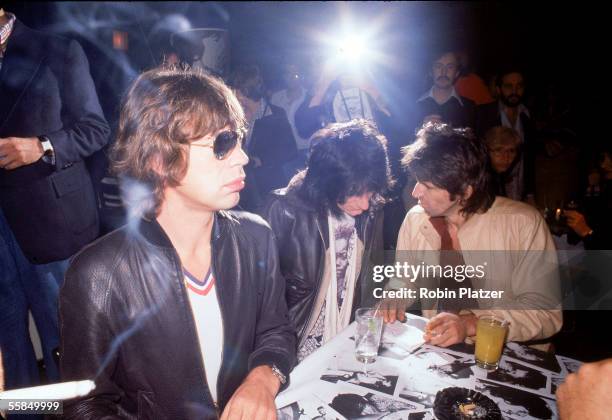 British rock and roll group the Rolling Stones sign autographs at a release party at the Trax nightclub for the band's 'Love You Live' album,...