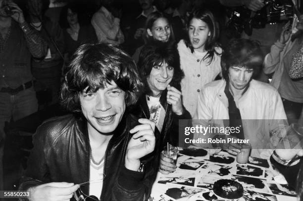 British rock and roll group the Rolling Stones sign autographs for fans at a release party at the Trax nightclub for the band's 'Love You Live'...