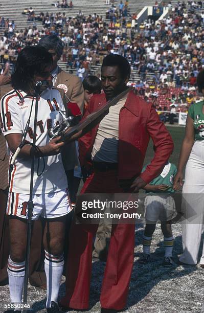 George Best of the LA Aztecs is presented a trophy by Pele of the New York Cosmos before the NASL League match between the New York Cosmos and LA...