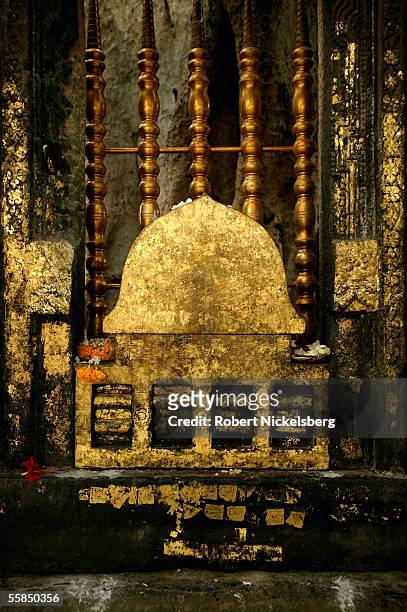 Religious pilgrim pray at the gold flaked gate beneath the Bodhi Tree July 25, 2005 in Bodhgaya, India. Buddha attained enlightenment in 528 B.C....
