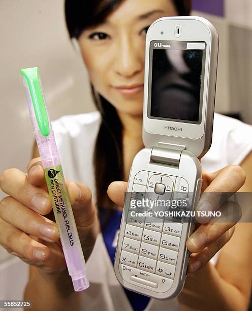 Japanese mobile communication giant KDDI employee displays a prototype model of a mobile phone, produced by Hitachi, powered by a direct methanol...