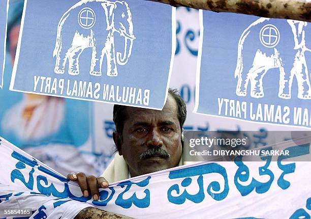 An activist of India's Bahujan Samaj Party political party listens to a speech by the party National President Mayawathi during a rally in Bangalore...