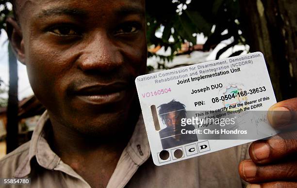 Joseph Duo a former Liberian government soldier, displays a card given to him and thousands of other former combatants in the Liberian civil war...