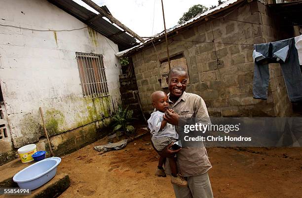 Joseph Duo a former Liberian government soldier, plays with his son, Kuku October 5, 2005 in Monrovia, Liberia. A picture of Duo jumping into the air...