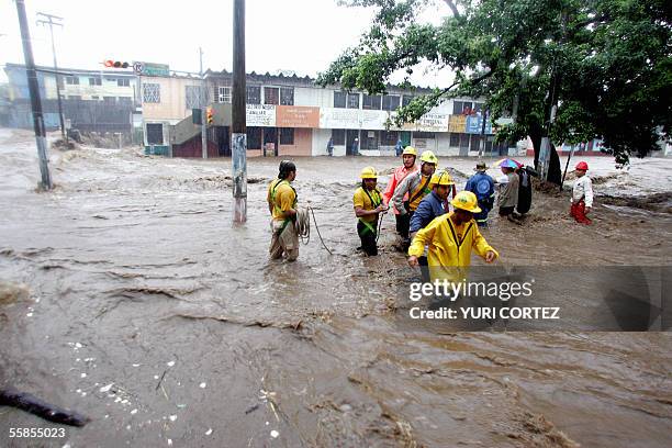 Rescuers scan San Salvador's flooded Modelo neighborhood 05 October 2005 after heavy rains hit El Salvador. Tropical Storm Stan only briefly reached...