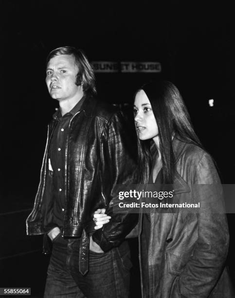 American actor Jon Voight and his second wife Marcheline Bertrand walk hand-on-arm along a street at night in front of a sign which reads 'Sunset...