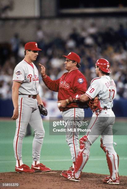 Roger Mason of the Philadelphia Phillies stands on the mound with manager Jim Fregosi and catcher Darren Daulton during game two of the 1993 World...