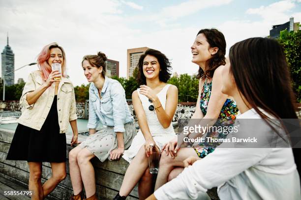 laughing female friends having drinks on deck - women power stock-fotos und bilder