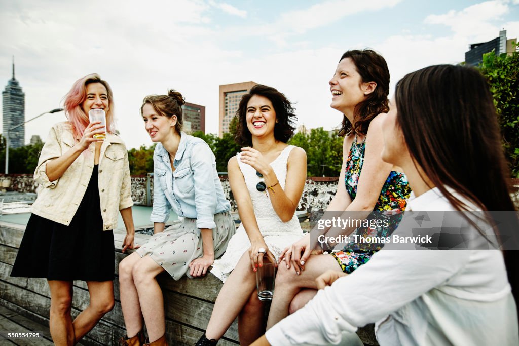 Laughing female friends having drinks on deck