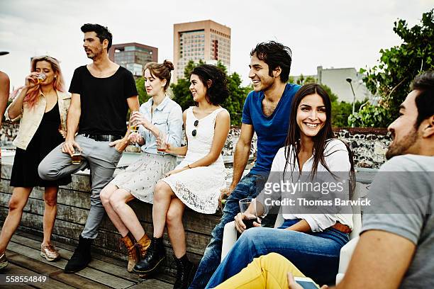 smiling group of friends having drinks together - medium group of people stock pictures, royalty-free photos & images