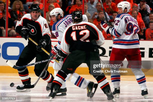 Right wing Jaromir Jagr of the New York Rangers moves the puck past defenseman Chris Therien and left wing Simon Gagne of the Philadelphia Flyers on...
