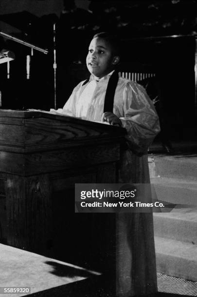 As a future American religious leader and civil rights activist, seven-year-old Al Sharpton preaches from a pulpit at Washington Temple, Brooklyn,...
