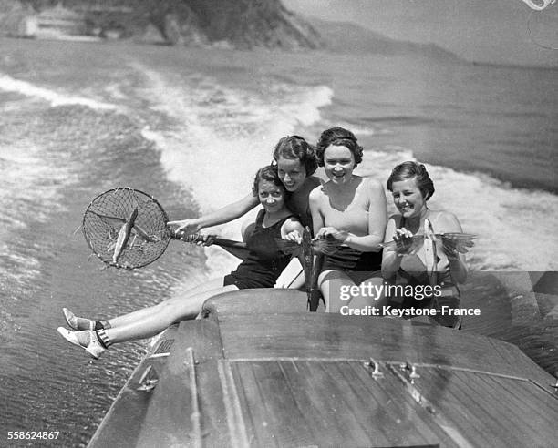 Quatre jeunes filles sur un canot à moteur avec un poisson volant qu'elles viennent d'attraper dans leur filet, en Californie, Etats-Unis le 30 avril...