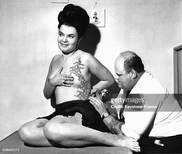 Femme se faisant tatouer par Horst Heinrich Streckenbach 'Tattoo Samy' à Francfort, Allemagne, le 23 novembre 1964.