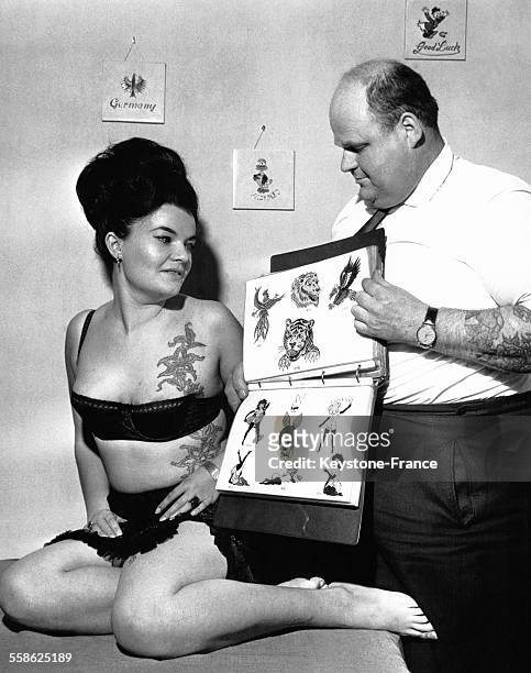 Horst Heinrich Streckenbach 'Tattoo Samy' montre des tatouages à une femme à Francfort, Allemagne, le 23 novembre 1964.