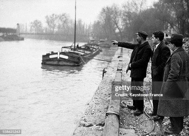 Un des sauveteurs montrant l'endroit où un canot a heurté le barrage de Créteil, France le 18 avril 1932.