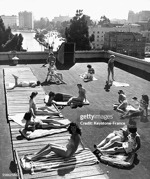Jeunes femmes bronzant sur le toit de la YWCA 'Blue Triangle Club' aux Etats-Unis, circa 1940.