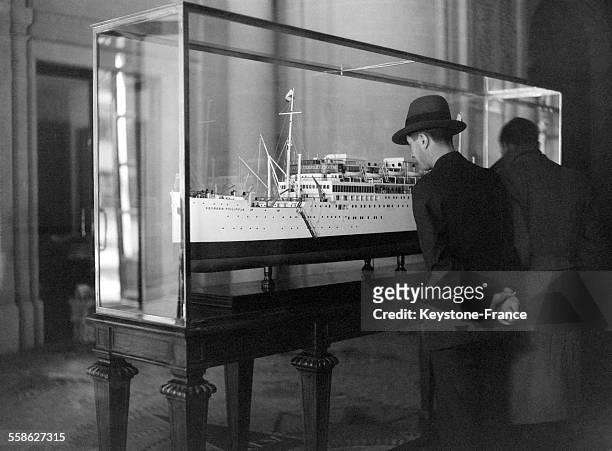 Un homme admire le modèle réduit du navire français tragiquement détruit 'Georges Philippar', en 1932 en France.