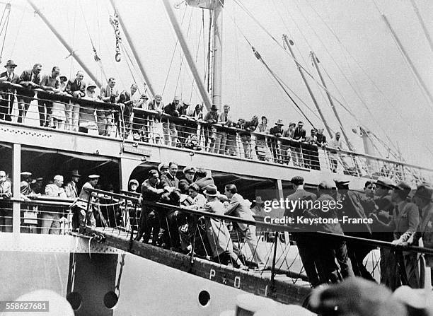 Des membres de l'équipage du cargo anglais le 'Comorin' empêchent des journalistes et d'autres hommes de monter à bord du bateau pour accueillir les...