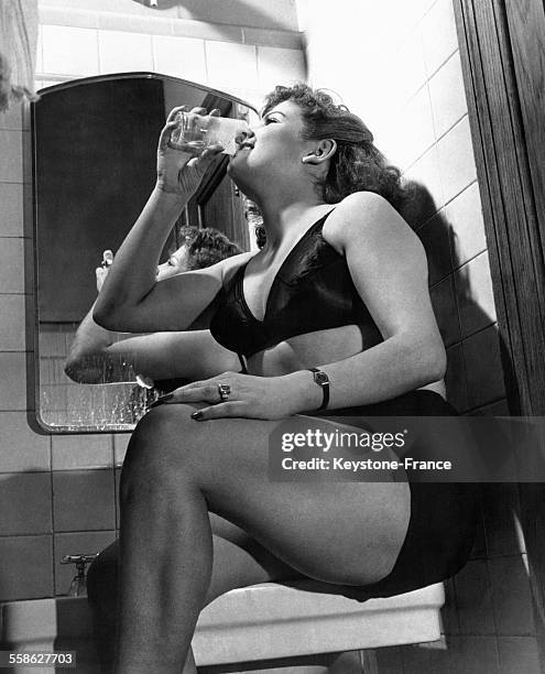 Monique Lasserre, Parisienne et cycliste, boit un verre d'eau dans les vestiaires avant de s'élancer sur la piste, à New York City, Etats-Unis en...